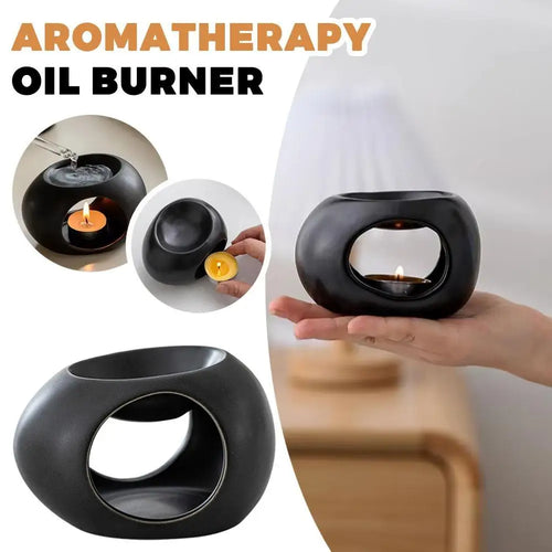 Black aroma oil burner with integrated reservoir and open window, lit candle