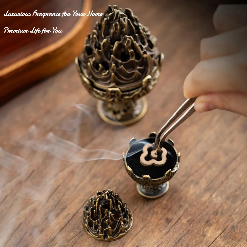 Copper-toned incense censer with ornate flame-lotus top and pedestal base, releasing smoke.