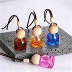 Mini glass car perfume diffuser: amber, blue, and pink bottles with wooden ball caps