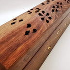 Carved rosewood incense box lid close-up with floral cutout holes and gold inlay
