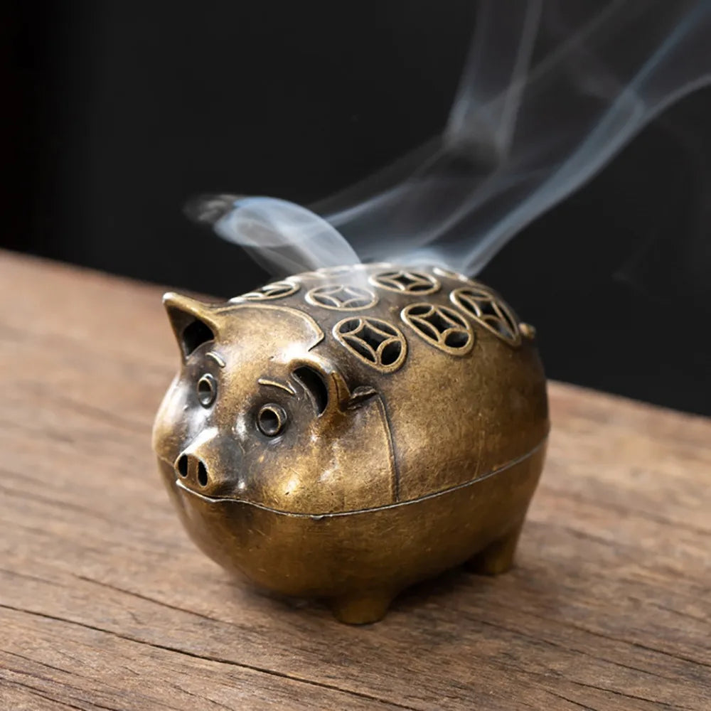 Brass incense holder cat with decorative top and swirling incense stick
