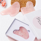 Pink heart-shaped jade roller stone inside a white gift box, glossy polished surface.