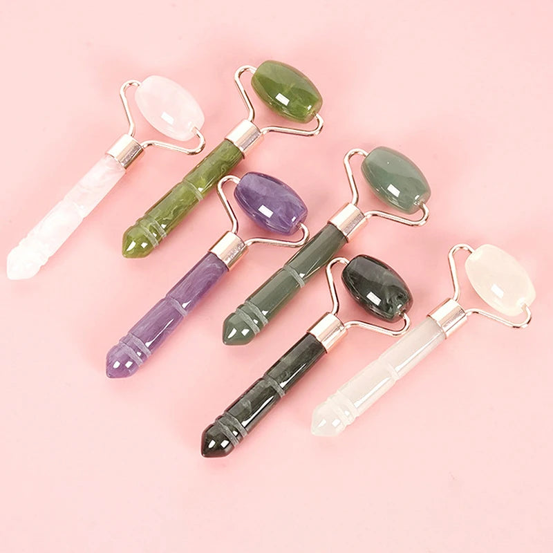 Assorted jade roller massagers with rose-gold frames in rose quartz, amethyst, and green shades
