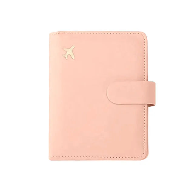 Light beige passport folio with stitched border, airplane emblem, and snap strap tab