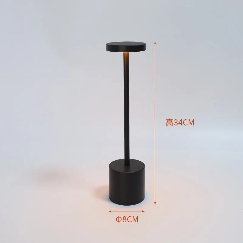 Black table lamp with slim stem and cylindrical base; 34cm height, 8cm width