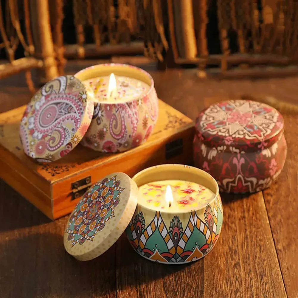 Floral aromatherapy candles in decorative tins, one lid open with flame