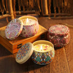 Floral aromatherapy candles in decorative tins, one lid open with flame
