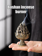 Boshan copper incense censer held in hand, ornate flame-top design with smoke