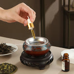 Ceramic electric incense warmer with metal dish as oil is poured into the burner top