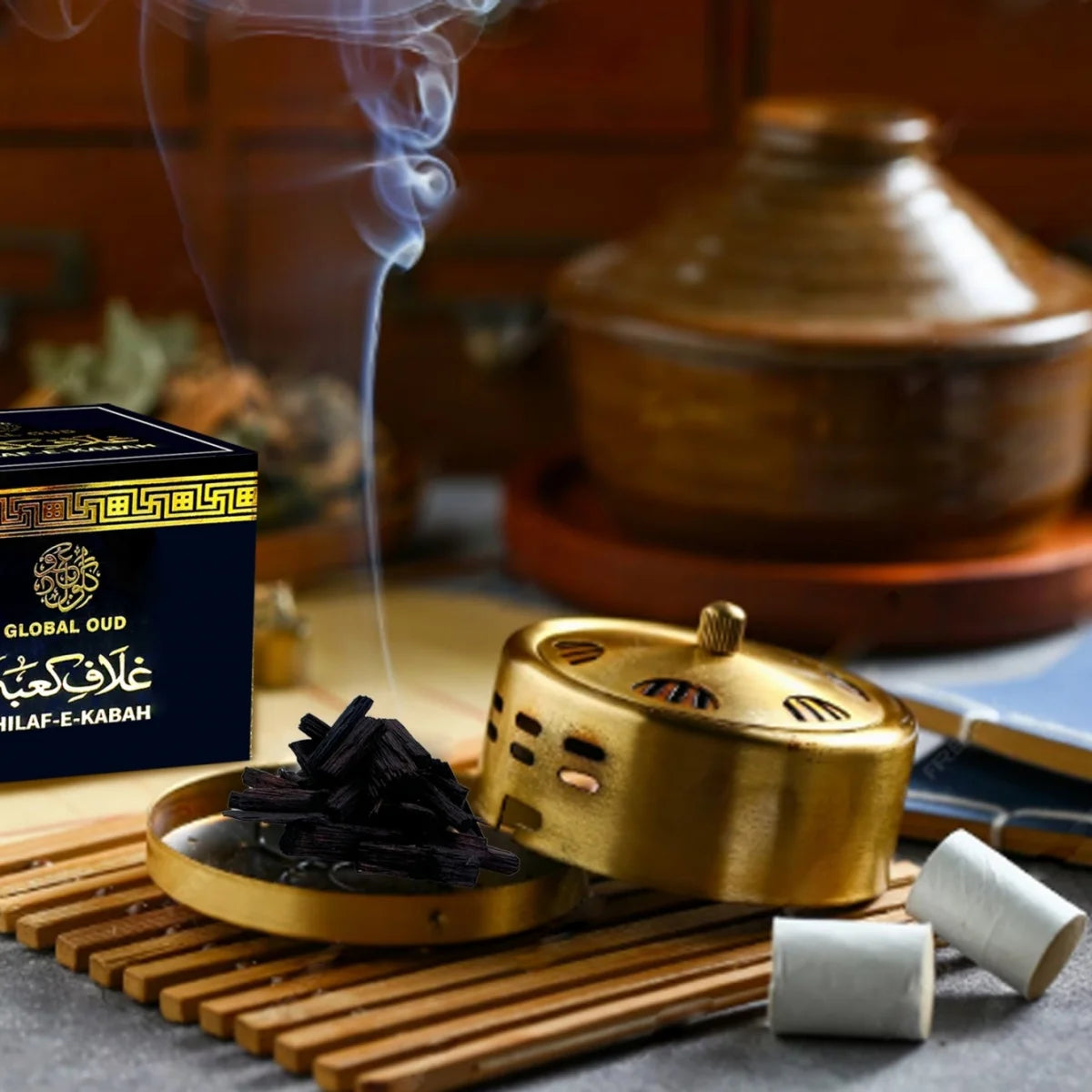 Incense smoke above a gold burner with stacked oud pieces and boxed incense
