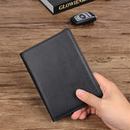 Compact travel document wallet, black front held in hand