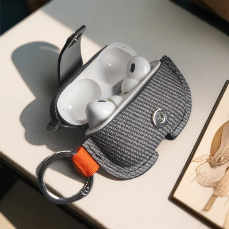 Dark gray herringbone AirPods cover with orange strap and silver key ring