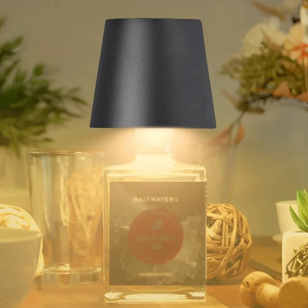 Black wine bottle LED lamp glowing warm white in a glass bottle display