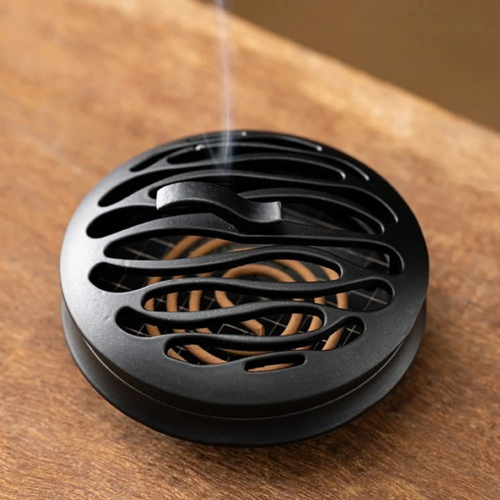 Black zinc alloy incense burner, close-up of oval cutouts and central burner well