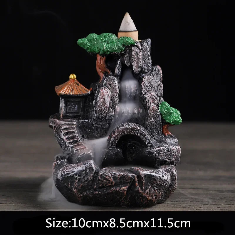 Waterfall incense burner, dark resin cave with green foliage and orange hut, flowing smoke