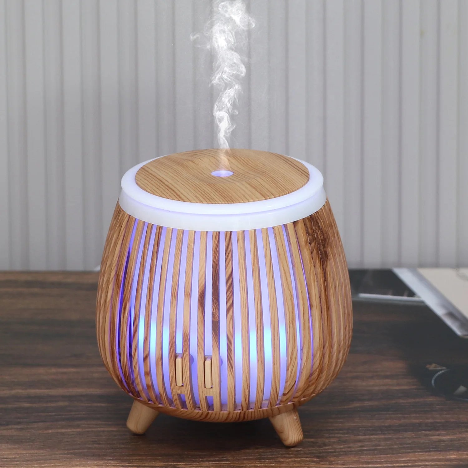 Ultrasonic aroma diffuser humidifier with wood-grain body, white light ring, blue glow, misting