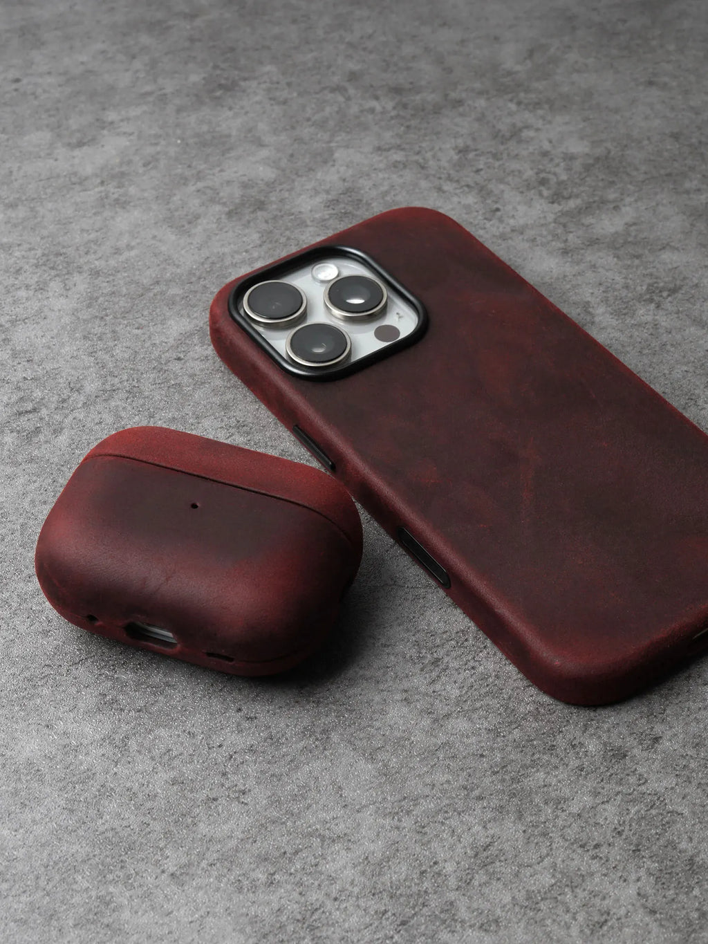 Burgundy leather AirPods case with rounded cover and side charging cutout
