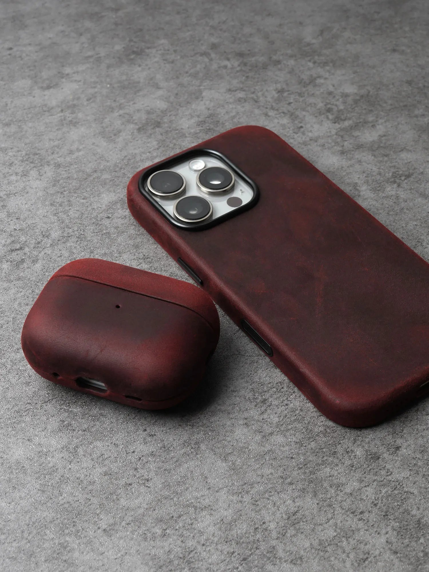 Burgundy leather AirPods case with rounded cover and side charging cutout