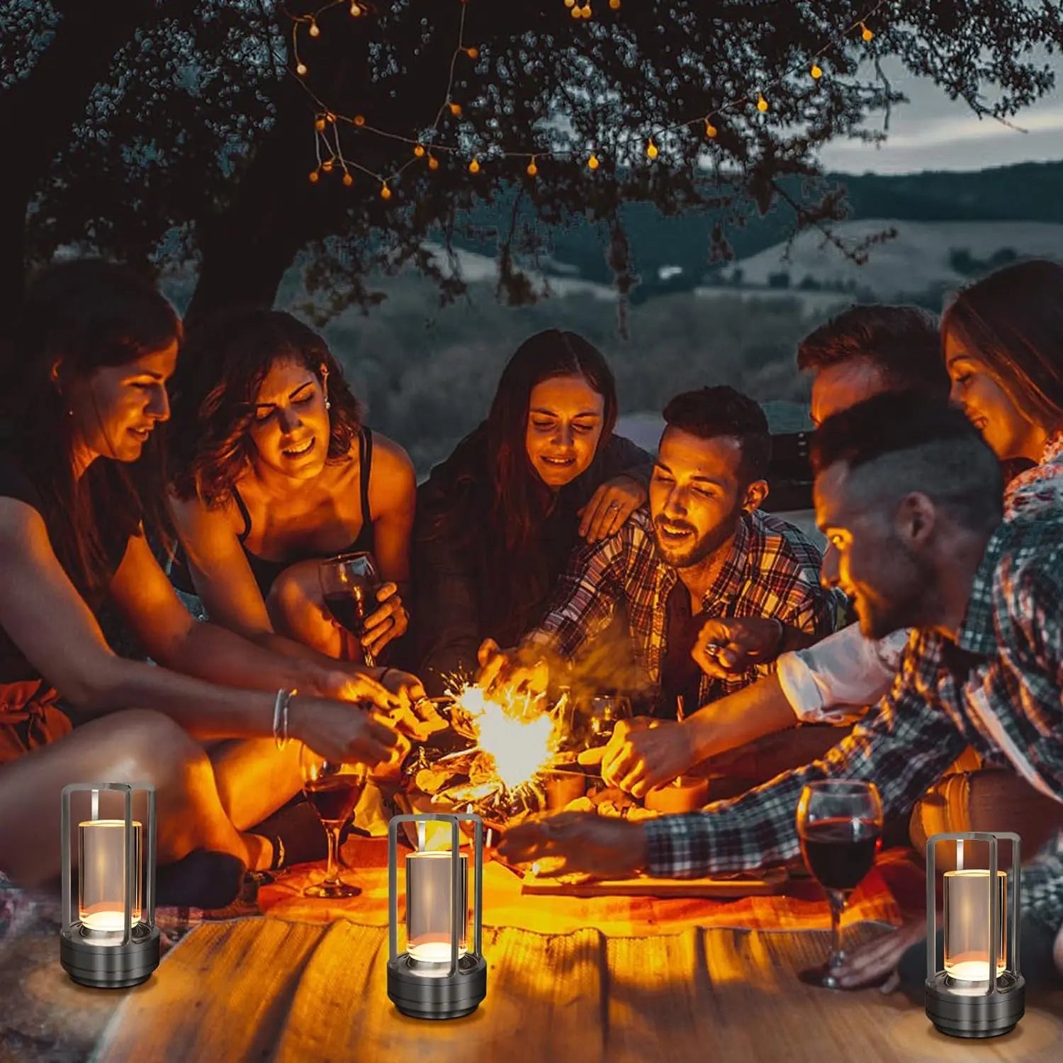 Gold cordless touch reading lamps on a wooden table during an outdoor gathering