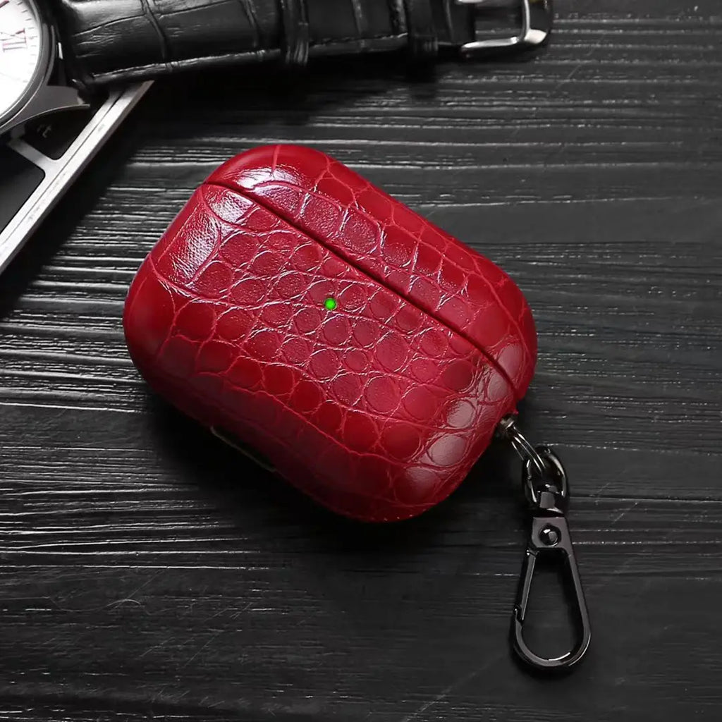 Ruby red crocodile-grain AirPods case with keychain carabiner clip.