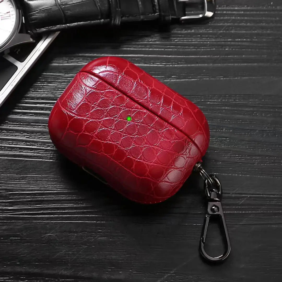 Ruby red crocodile-grain AirPods case with keychain carabiner clip.