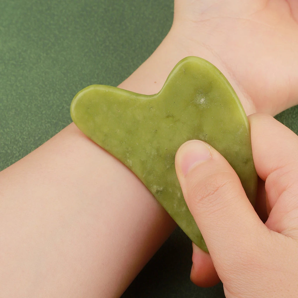Forest Jade Herz-Guasha, glatte Steinoberfläche, in den Fingern gehalten