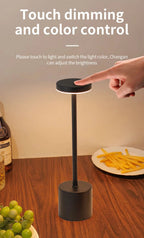 Black touch-dimming table lamp with round top and cylindrical base; hand control