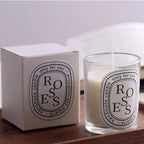 Glass jar scented candle with box; lit wick over white wax