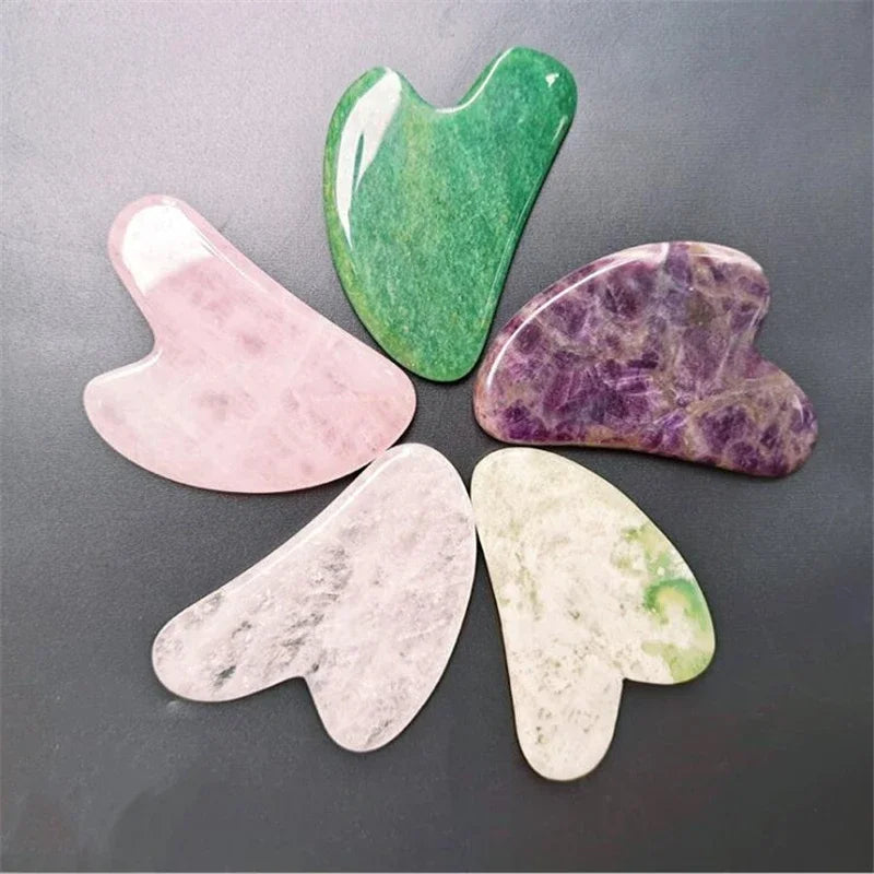 Six heart-shaped jade roller stones arranged together in green, rose, purple, white, cream, and olive.