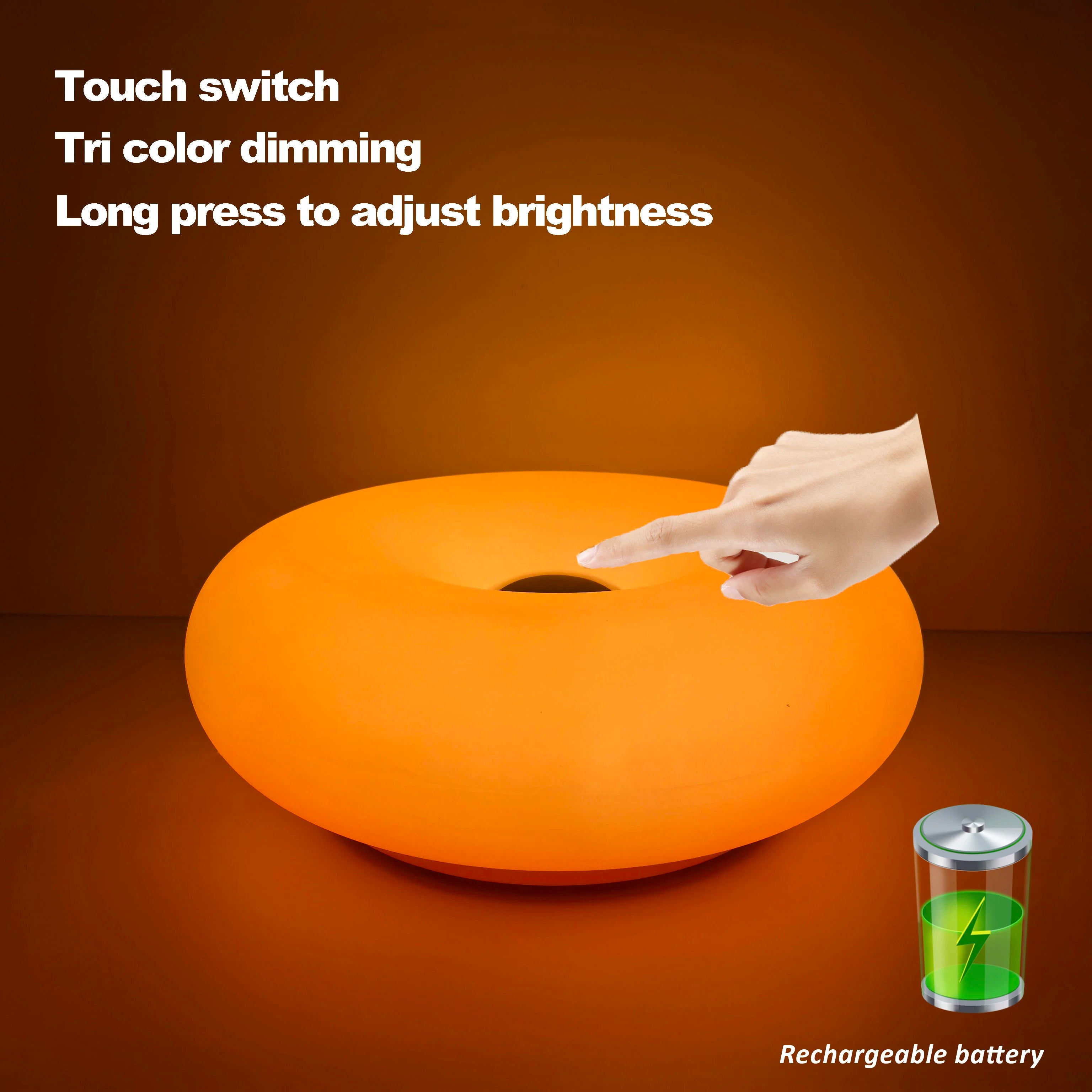 Orange glowing donut table lamp with hand touching center opening.