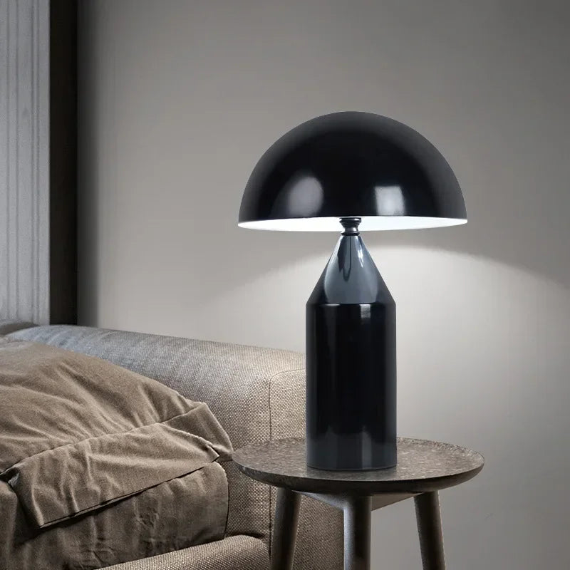 Black mushroom LED table lamp on round side table, dome shade and column base