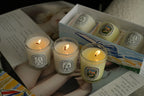 French Botanical scented candles lit in glass jars, warm flames visible