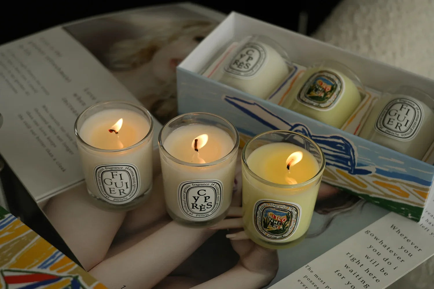 French Botanical scented candles lit in glass jars, warm flames visible
