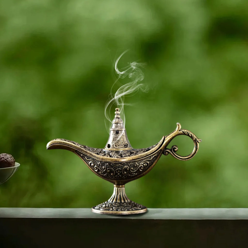 Antique brass Aladdin lamp incense burner with engraved pattern and thin smoke plume
