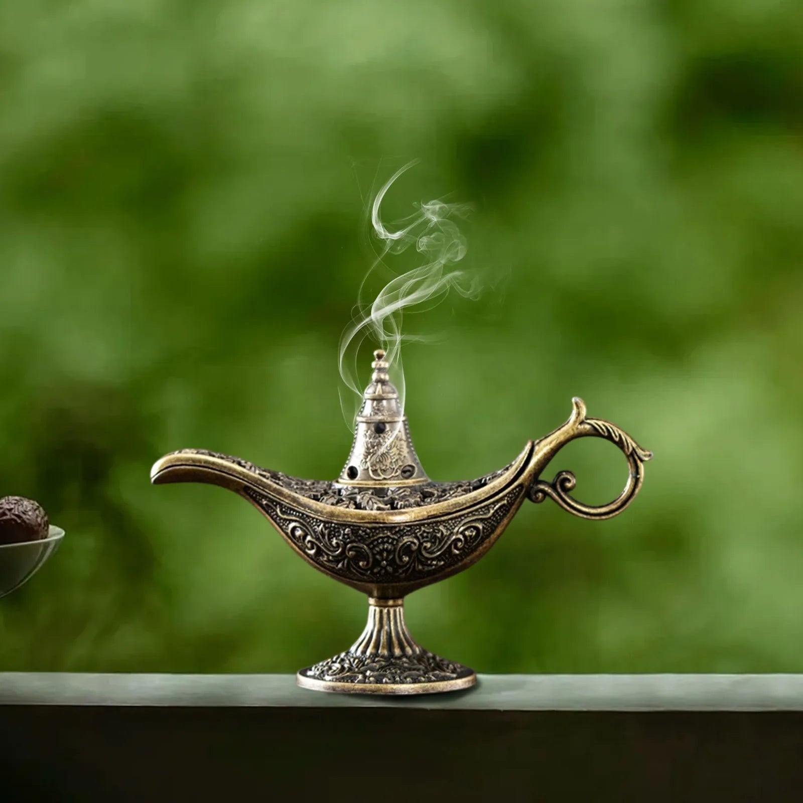 Antique brass Aladdin lamp incense burner with engraved pattern and thin smoke plume