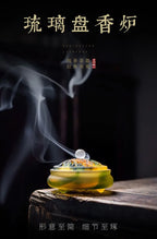 Amber glass incense vessel on wooden surface with smoke and Chinese title