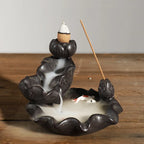 Backflow incense burner with seated hand shape, wood incense stick and smoke pool