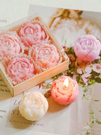 Floral candle set: pink rose-shaped candles in open box with wicks