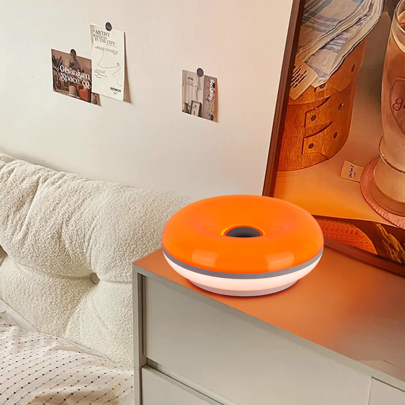 Orange donut table lamp with center opening on a bedside table