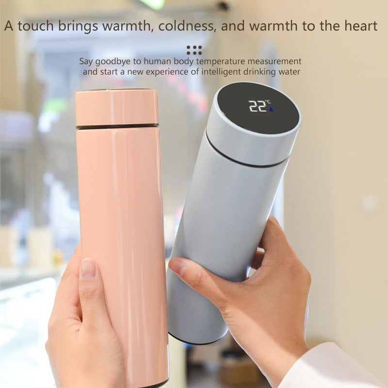 Pink smart thermos with LED temperature display, held beside a white thermos