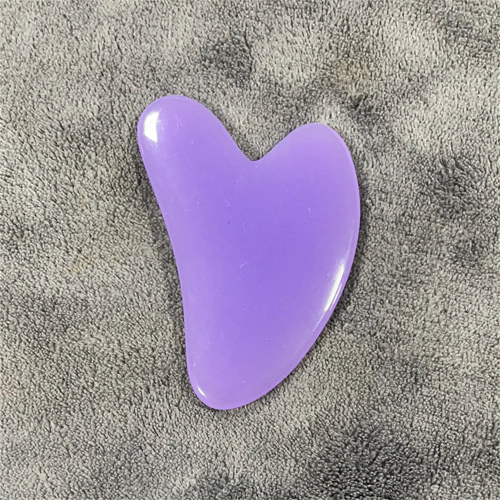 Amethyst gua sha stone with glossy purple, curved teardrop shape.
