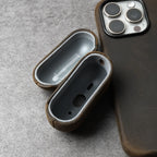 Open brown leather AirPods case showing interior lining and charging port