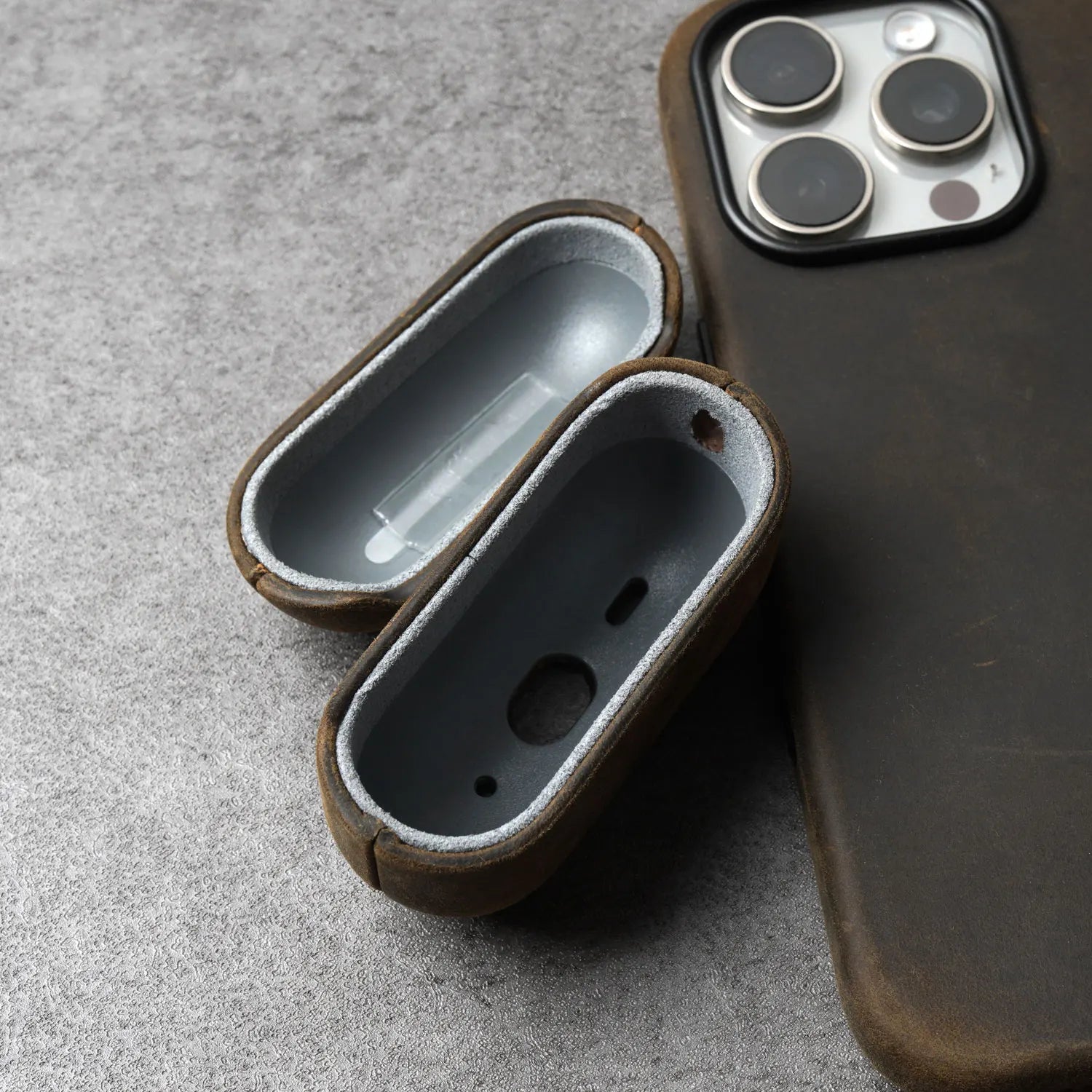 Open brown leather AirPods case showing interior lining and charging port