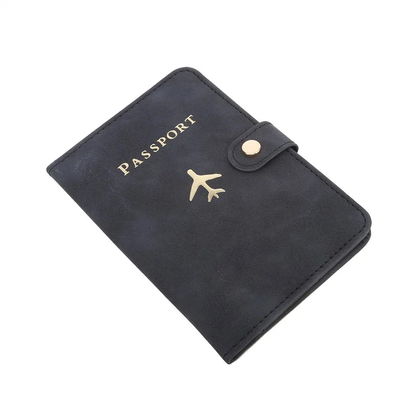Midnight black passport cover with airplane emblem and round snap button at top corner