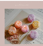 Rose-scented candle gift box with pastel rose candles in purple, peach, and yellow tones