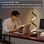 Spiral dimmable LED bedside lamp with warm white glow; black base and wavy light
