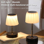 Cordless LED desk lamp, warm glowing white shade, black base, adjustable height