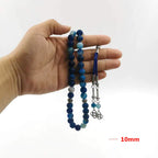 Blue agate prayer beads in hand with silver-tone end pieces and braided tassel