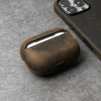 Brown leather AirPods case with curved shell and front opening for earbuds