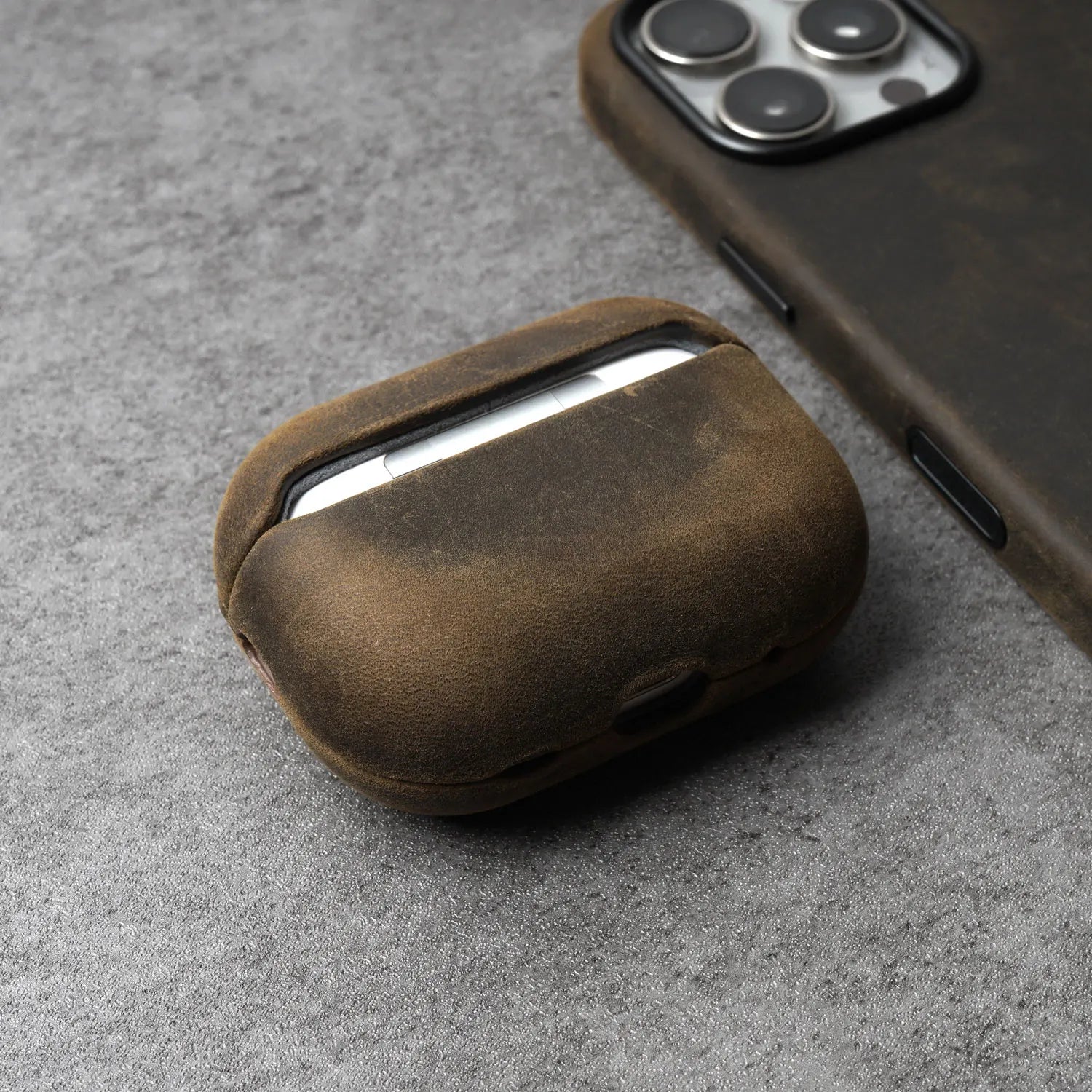 Brown leather AirPods case with curved shell and front opening for earbuds